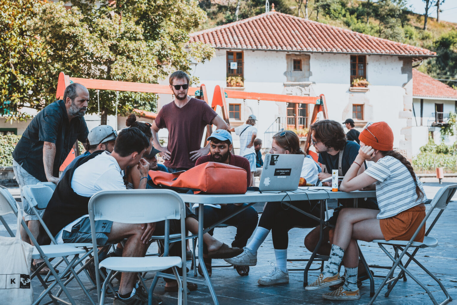 Students designing at tables on the village square in Zaldibia