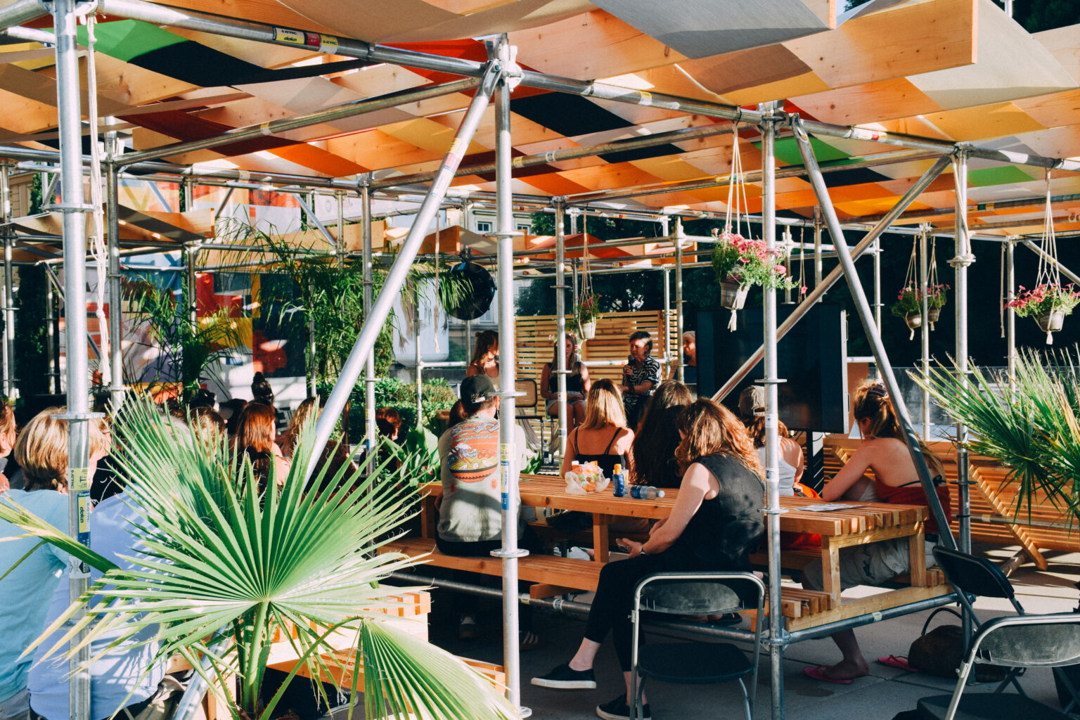 Tables, palms and people under the canopy