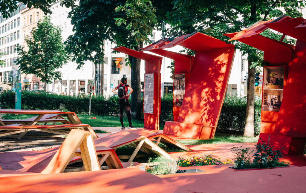 Red modular pavilion on a public square in Innsbruck