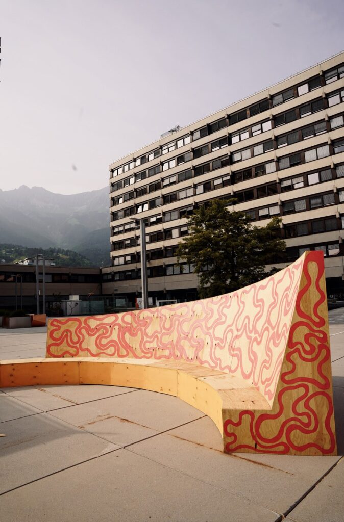 Curved timber bench with painted pattern